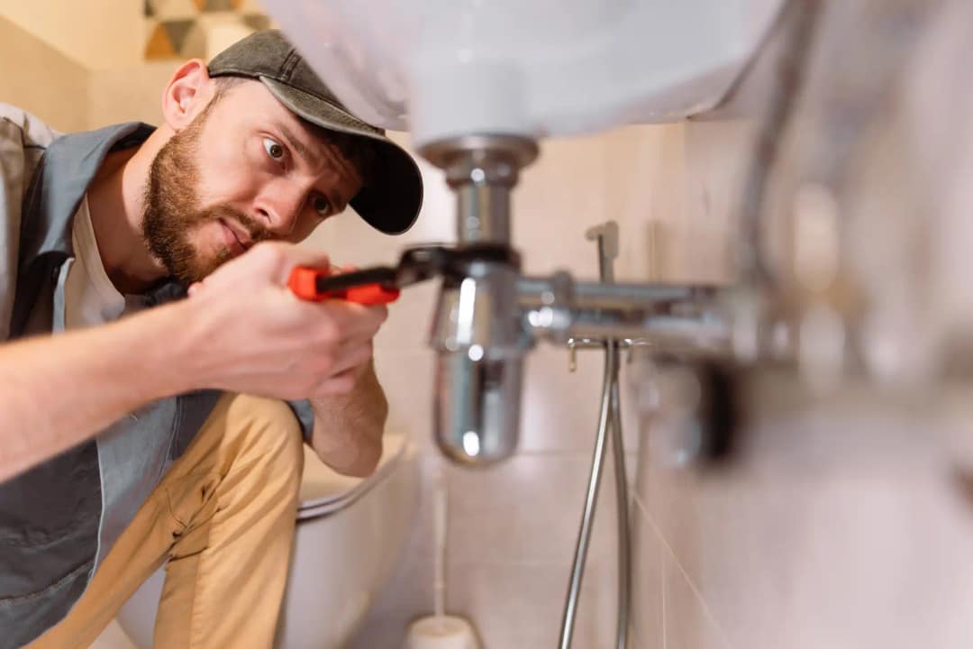 Homme qui fait un dépannage de plomberie pour réparer une fuite