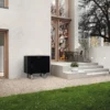 Photo de l'unité extérieure de la pompe à chaleur reliée à la Chaudière VIESSMAN Gaz à Condensation Vitodens 200-W, installée contre le mur de la maison près du jardin