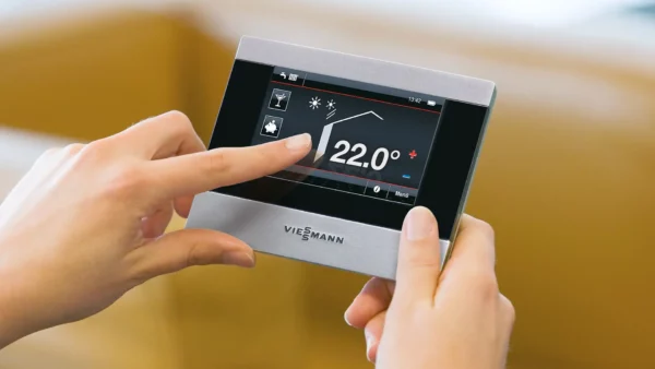 Femme sur son thermostat VIESSMAN qui contrôle la température de sa chaudière