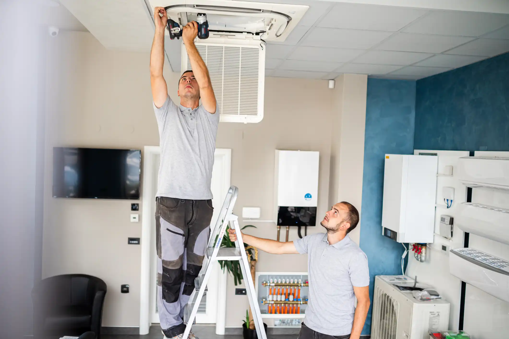 Deux hommes qui installent une ventilation